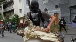 Ein Plünderer mit einer Christus-Statue / Kirche in Not Chile
