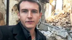 Xavier Stephen Bisits, Projektreferent von „Kirche in Not“, vor zerstörten Gebäuden in Aleppo / Kirche in Not