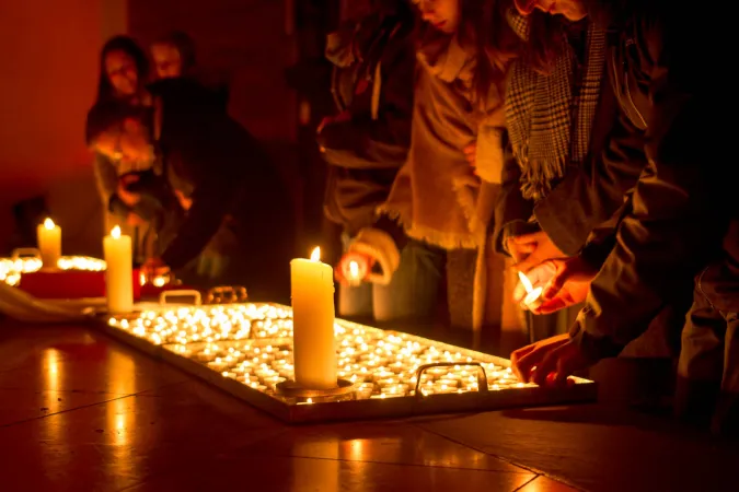 Licht ins Dunkel: Die vor der Kirche verteilten Kerzen werden im Gotteshaus angezündet.