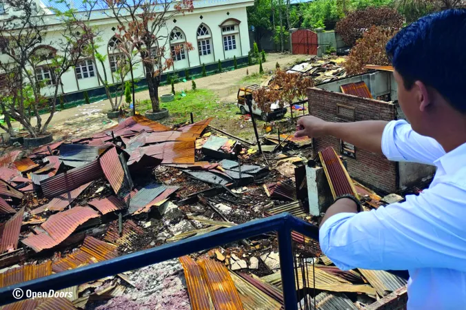 Ein christlicher Leiter blickt auf die Trümmer seiner Kirche in Manipur, die bei Ausschreitungen im Mai 2023 zerstört wurde.