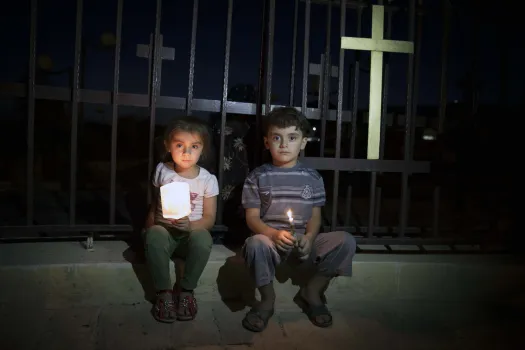 Aus dem Irak geflohene Kinder sitzen neben einer Marienstatute. Die beiden jungen Christen kommen aus Mosul, einer früher christlich geprägten, die vom Islamischen Staat "ethnisch gesäubert" wurde.  / Christiaan Triebert via Flickr (CC BY 2.0)