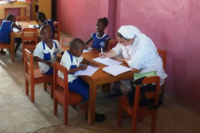 Eine Ordensfrau der Schwestern vom Barmherzigen Jesus macht mit Kindern Hausaufgaben