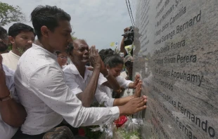 Angehörige vor einem Denkmal für die Todesopfer der Osteranschläge. / Kirche in Not