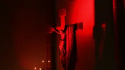 Rot erleuchtetes Kreuz bei einem Gebetsabend für verfolgte Christen von "Kirche in Not".
 / Kirche in Not