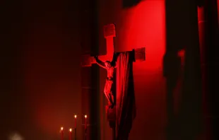 Rot erleuchtetes Kreuz bei einem Gebetsabend für verfolgte Christen von "Kirche in Not".
 / Kirche in Not