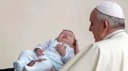 Ein achtsamer Papst Franziskus mit Baby. Aufnahme vom 15. Oktober 2014. / Mazur/catholicnews.org.uk