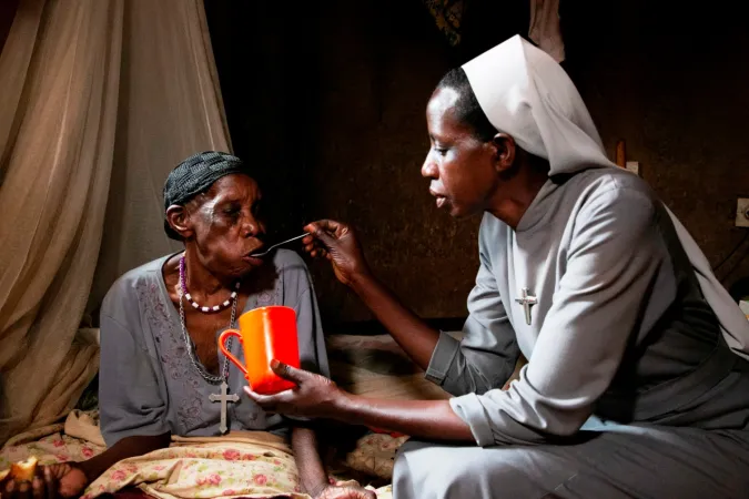 Eine Ordensschwester in Ruanda versorgt eine ältere Frau. 