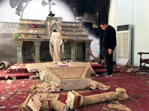 Priester im Altarraum seiner zerstörten Kirche in Karamles (Irak).