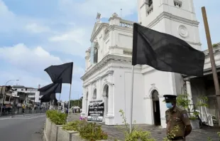 Ein Polizist steht am 21. August 2021 vor der St. Anthony's Church in Colombo Wache neben einem Plakat und schwarzen Fahnen. 
 / Ishara S. Kodikara/AFP via Getty Images