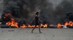 Eine Frau läuft an brennenden Barrikaden vorbei, die gegen Präsident Jovenel Moise protestierende Demonstranten am 10. Februar in Port-au_prince errichtet haben.  / Hector Retamal / AFP  Getty Images 