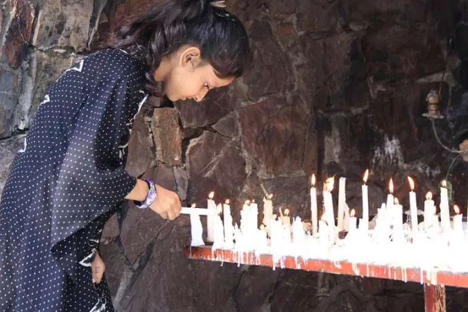 Ein junges Mädchen entzündet eine Gebetskerze in einem marianischen Schrein in Pakistan