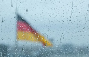 Deutsche Flagge hinter Fenster mit Regentropfen / Francesco Luca Labianca / Unsplash