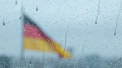 Deutsche Flagge hinter Fenster mit Regentropfen / Francesco Luca Labianca / Unsplash
