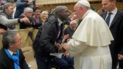 Ein Mann, der von der französischen Zeitung "La Croix" als Emmanuel Abayisenga identifiziert wurde, begrüßt am 11. November 2016 Papst Franziskus in der Audienzhalle des Vatkans. / Vatican Media