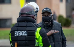 Ein Demonstrant diskutiert mit einem Polizisten der Minnesota State Patrol vor der Polizeiwache in Brooklyn Center, Minnesota, / Kerem Yucel/AFP via Getty Images