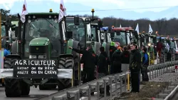 Französische Bauern stehen neben ihren Zugmaschinen und blockieren die Straße während einer Demonstration an der deutsch-französischen Grenze im elsässischen Ottmarsheim am 1. Februar 2024. / PATRICK HERTZOG/AFP via Getty Images