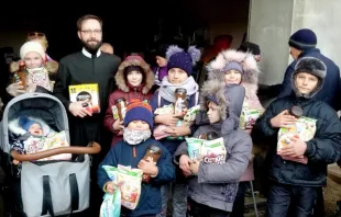 Basilianerpater Ignatius Moskalyuk mit Kindern, die in seinem Kloster Lebensmittel erhalten (Archivbild vom Dezember 2022) / Kirche in Not