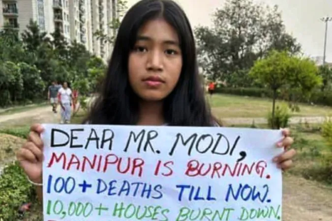 Eine junge Frau aus dem Bundesstaat Manipur zeigt ein an den indischen Premierminister Narendra Modi gerichtetes Protestplakat