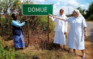 Die zurückgekehrten Schwestern vor dem Ortsschild von Dómuè im Nordwesten von Mosambik / Kirche in Not