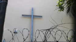 Kreuz hinter Stacheldraht vor einer Kirche in Venezuela / Kirche in Not