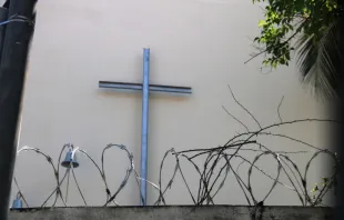 Kreuz hinter Stacheldraht vor einer Kirche in Venezuela / Kirche in Not