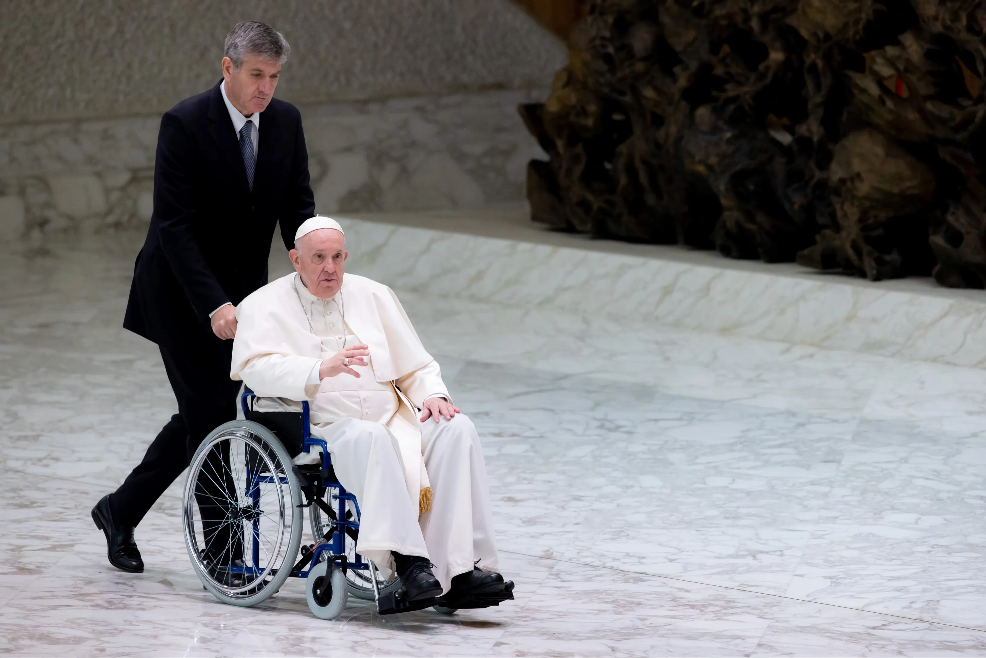 Papst Franziskus wird am 5. Mai 2022 im Rollstuhl zu einer Audienz in die Audienzhalle gebracht.