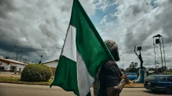 Mann mit nigerianischer Flagge / Emmanuel Ikwuegbu / Unsplash