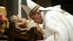 Papst Franziskus küsst das Jesuskind in der Krippe bei der Christmette im Petersdom am 24. Dezember 2018 / Vatican Media