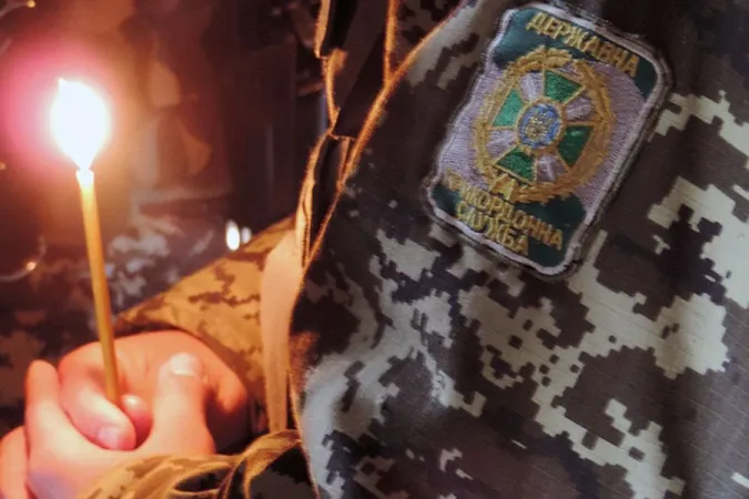 Militärseelsorger mit Gebetskerze in der Ukraine