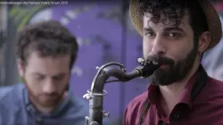 Der Saxophonspieler bemerkt im Video einen alten Mann, der bettelt. / Screenshot