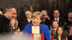 Kanzlerin Merkel mit der Lampe des Friedens / Susanne Dedden / CNA Deutsch 
