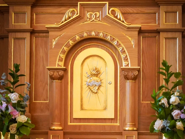 Der Tabernakel im neugestalteten Sanktuarium zeigt das Herz Jesu mit Dornenkrone und Kreuz – ein klassisches Symbol der Liebe Christi und des eucharistischen Geheimnisses. Das Werk stammt aus der Hand des jungen Schreiners John Hayden.