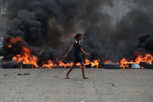 Eine Frau läuft an brennenden Barrikaden vorbei, die gegen Präsident Jovenel Moise protestierende Demonstranten am 10. Februar in Port-au_prince errichtet haben.  / Hector Retamal / AFP  Getty Images 