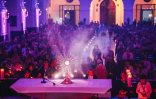 Gläubige beten vor dem Allerheiligsten bei der Adoratio 2023 in Altötting. Der Kongress widmet sich dem Thema der Herrlichkeit Gottes und lädt die Teilnehmer ein, sich von seiner Liebe berühren zu lassen. / Susanne Schmidt / Bistum Passau