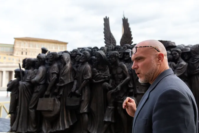 Der kanadische Bildhauer Timothy Schmalz neben seiner Skulptur, die Migranten und Flüchtlinge darstellt. 