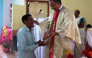 Bishof George Pallipparambil von Miao gibt einem Pfarreimitglied ein Neues Testament / Bistum Miao