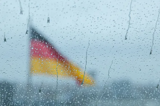 Deutsche Flagge hinter Fenster mit Regentropfen / Francesco Luca Labianca / Unsplash