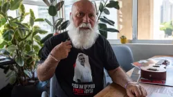 Sein Lebensziel: Seinen Sohn heimzubringen. Danny Miran zeigt das T-Shirt mit einem Foto seines Sohnes Omri, einem der am 7. Oktober 2023 entführten Israelis, die immer noch in Gaza als Geiseln gehalten werden. Auf dem T-Shirt lautet die hebräische Aufschrift: "Bringt sie jetzt nach Hause!", das Motto der Kampagne zur Rückführung der Geiseln. / Marinella Bandini
