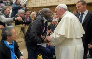 Ein Mann, der von der französischen Zeitung "La Croix" als Emmanuel Abayisenga identifiziert wurde, begrüßt am 11. November 2016 Papst Franziskus in der Audienzhalle des Vatkans. / Vatican Media