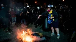 Eine Demonstrantin versucht ein von anderen Aktivisten entzündetes Feuer zu löschen: Portland am 31. Juli 2020. / Alisha JUCEVIC / AFP via Getty
