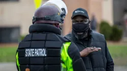 Ein Demonstrant diskutiert mit einem Polizisten der Minnesota State Patrol vor der Polizeiwache in Brooklyn Center, Minnesota, / Kerem Yucel/AFP via Getty Images