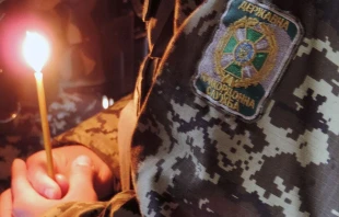 Militärseelsorger mit Gebetskerze in der Ukraine / Kirche in Not / Aid to the Church in Need (ACN)