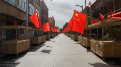 Straße mit Marktständen in Xinjiang: An jedem Stand ist eine chinesische Flagge angebracht. / Chris Redan/Shutterstock