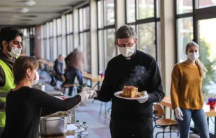 Kardinal Rainer Maria Woelki hilft bei der Essensausgabe für Obdachlose. Das Foto entstand Ende März 2020 während der Corona-Pandemie, als der Kölner Erzbischof die Tore des Priesterseminars öffnete, um den Obdachlosen jeden Mittag eine warme Mahlzeit und eine Dusche anzubieten. / Erzbistum Köln / Henning Schoon